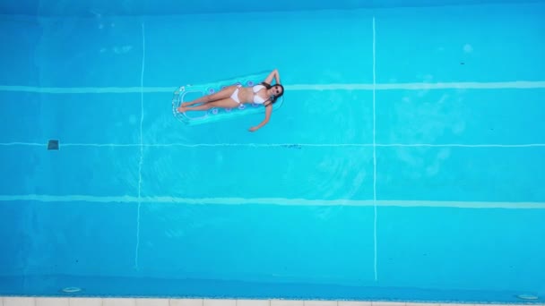 Hübsches Mädchen liegt auf Luftmatratze im Schwimmbad — Stockvideo