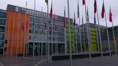 LUXEMBOURG, EUROPE - 1 Eylül 2025 - Lüksemburg 'da bulutlu bir günde Avrupa Parlamentosu binasının önünde birçok dünya bayrakları dalgalanmaktadır