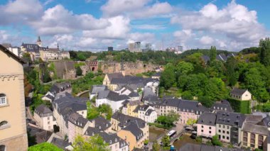 Lüksemburg 'un tarihi Grund bölgesinin panoramik manzarasında büyüleyici mimari, verimli yeşillik ve modern binalar ve Neumunster Abbey' in yanı sıra Alzette Nehri yer alıyor.