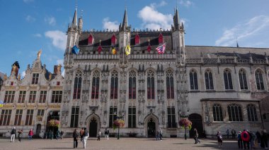 BRUGES, BELGIUM - 15 EYLÜL 2025 - Burg Meydanı 'ndaki tarihi Stadhuis binası güneşli bir günde göz kamaştırıcı Gotik mimari sergiliyor