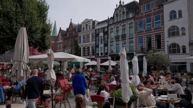 HAGUE, NETHERLANDS - 14 Eylül 2025 - Hollanda, Lahey 'de kalabalık bir caddedeki açık bir kafede insanlar rahatlıyor ve sosyalleşiyor