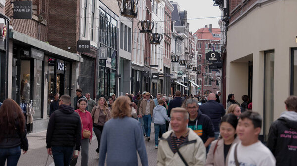 THE HAGUE, NETHERLANDS - SEPTEMBER 14, 2025 - People walking along a busy shopping street in The Hague, Netherlands, with crown decorations