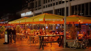 ROTTERDAM, NETHERLANDS - 13 Eylül 2025 - İnsanlar Rotterdam, Hollanda 'da gece bir açık bar terasında dinleniyor ve sosyalleşiyorlar