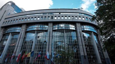 BRÜKSEL, BELGIUM - 12 Eylül 2025 - Avrupa Birliği yönetimini simgeleyen modern mimari ve bayrakları gösteren Avrupa Parlamentosu binası cephesi