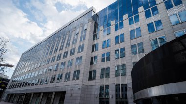 BRÜKSEL, BELGIUM - 12 Eylül 2025 - Avrupa Parlamentosu modern bina cephesi cam pencereli bulutlu bir gökyüzünü yansıtıyor