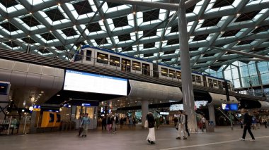 HAGUE, NETHERLANDS - 14 Eylül 2025 - Çağdaş bir tren istasyonunda yürüyen ve ayrılan trenler