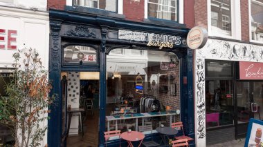 The HAGUE, NETHERLANDS - 14 Eylül 2025 - Burger restaurant Frenchie 's Burgers mağazası Lahey' de masa ve sandalyeli