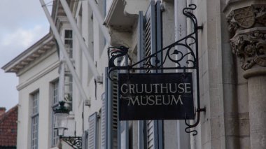 BRUGES, BELGIUM - 15 EYLÜL 2025 - Gruuthuse Müzesi tabelasında tarihi bir binanın ön cephesinde demiri gösteren