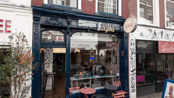 The HAGUE, NETHERLANDS - 14 Eylül 2025 - Burger restaurant Frenchie 's Burgers mağazası Lahey' de masa ve sandalyeli