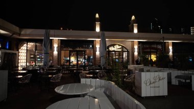 SCHENINJEN, NETHERLANDS - 14 Eylül 2025 - ChouChou restoran terası geceleri aydınlatılmış, misafirler için hazır