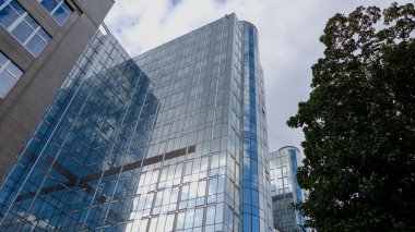 BRÜKSEL, BELGIUM - 12 Eylül 2025 - Brüksel 'deki Paul Henri Spaak binasının modern cam cephesi bulutlu bir gökyüzünü yansıtıyor