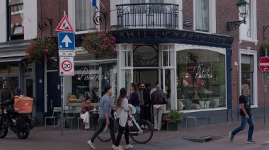 HAGUE, NETHERLANDS - 14 Eylül 2025 - İnsanlar Lahey 'deki bir kafe ve tarihi binalarla canlı bir sokak sahnesinin keyfini çıkarıyorlar