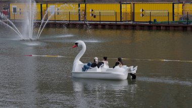 HAGUE, NETHERLANDS - 14 Eylül 2025 - Hollanda, Lahey 'de bir kanalda bir kuğu teknesini dinlendirip pedal çeviren insanlar