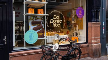 HAGUE, NETHERLANDS - 14 Eylül 2025 - Sertifikalı bir B şirketinin çikolata dükkanının önünde park edilmiş bisiklet