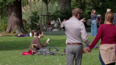 HAGUE, NETHERLANDS - 14 Eylül 2025 - İnsanlar parkta dinleniyor, bazıları piknik yapıyor ve diğerleri boş zamanların tadını çıkarıyor