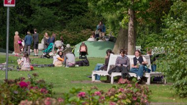 HAGUE, NETHERLANDS - 14 Eylül 2025 - Hollanda, Lahey 'deki bir şehir parkında güneşli bir günde insanlar dinleniyor ve oynuyorlar