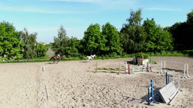 yukarıdan görüntülemek, havadan video çekim, eğitim kum alan, Bahçesi, biniciler, jockeys binmek atlar, atlarla bariyer yanında çeşitli egzersizler gerçekleştirin. yaz, açık havada,