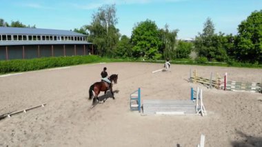 yukarıdan görüntülemek, havadan video çekim, eğitim kum alan, Bahçesi, biniciler, jockeys binmek atlar, atlarla bariyer yanında çeşitli egzersizler gerçekleştirin. yaz, açık havada,