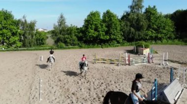 yukarıdan görüntülemek, havadan video çekim, eğitim kum alan, Bahçesi, biniciler, jockeys binmek atlar, atlarla bariyer yanında çeşitli egzersizler gerçekleştirin. yaz, açık havada,