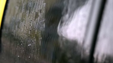 yakın çekim, üzerine araba cam windows yağmur damla akarsu çok sayıda aşağı bırakır. onun ağır, sağanak yağmur. yağmur damlaları araba camına