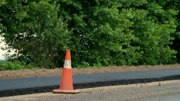 Traffic Cone on road. Road construction works , road repair. On the road there is fresh asphalt laid on one side of the traffic. Construction and repair of highway — Stock Video