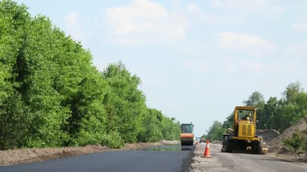 高速道路、ローラー圧縮機機の修復、アスファルト フィニッシャー新しい新鮮なアスファルト舗装を敷設のトラフィックの 1 つの側面をカバーします。道路建設工事 — ストック動画