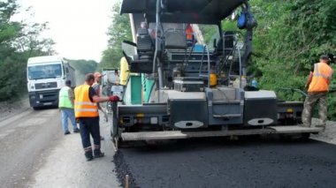 Cherkassy Region, Ukrayna - 31 Mayıs 2018: bir otoyol tamiri, yol yapımı çalışır. Çalışanlar asfalt elinizdeki. Bir sürü özel ekipman, asfalt zemin döşemeleri için makineler