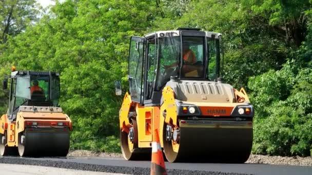 Cherkassy Region, Ukraina - 31 maj 2018: reparation av en motorväg, vägbyggen fungerar. rullen komprimator maskin och asfalt efterbehandlaren om en ny fräsch asfaltbeläggning, — Stockvideo