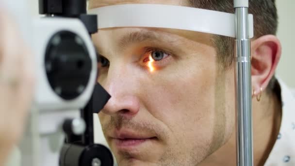 Лицо крупным планом, человек делает тест глаз с бесконтактным тонометром, щекотливое зрение, внутриглазное давление в оптической клинике, офтальмологической лаборатории — стоковое видео