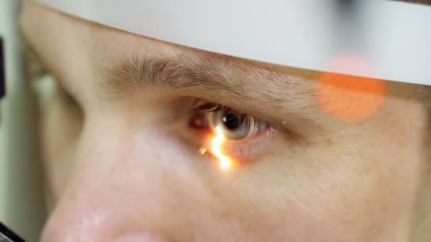 Close-up facial, homem fazendo teste ocular com tonômetro sem contato, visão de mastigação, pressão intraocular na clínica óptica, laboratório oftalmológico — Vídeo de Stock