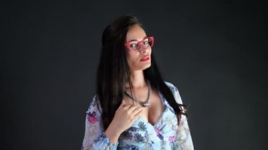 kırmızı seksi esmer kadın portresi kim eroticly dudakları ve şakacı şık gözlük, gözlük ve stüdyoda poz fotoğraf makinesi, cinsel açıdan bakarak çalışır. koyu gri arka plan.