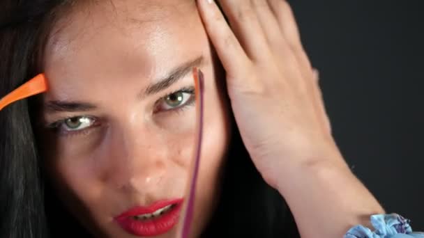 Porträtt av en sexig brunett kvinna med röda läppar som eroticly och försöker lekfullt på eleganta Glasögon, Glasögon och sexuellt tittar kameran i studio. mörkgrå bakgrund. — Stockvideo