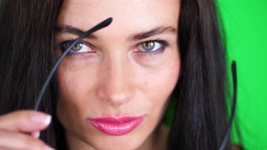 yeşil renkli, chromeakey. şık gözlük, Gözlük, kırmızı dudaklar ile seksi esmer kadın portresi eroticly, şakacı, hamle cinsel kameraya bakarak, stüdyoda poz.