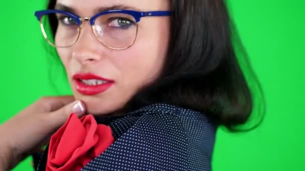 Fundo verde, cromeakey. retrato de uma mulher morena sexy com lábios vermelhos, em óculos elegantes, óculos, eroticly, brincando se move, olhando sexualmente para a câmera, posando em estúdio . — Vídeo de Stock