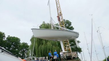 Kiev, Ukrayna, Yatçılık-Temmuz 29, 2018: Dinyeper Nehri kıyısında pier, üzerine beyaz bir yat Yükaldırma vinç yükseltir. yere otopark özel sabitleme koymak