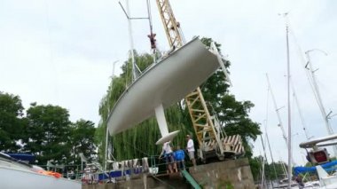 Kiev, Ukrayna, Yatçılık-Temmuz 29, 2018: Dinyeper Nehri kıyısında pier, üzerine beyaz bir yat Yükaldırma vinç yükseltir. yere otopark özel sabitleme koymak.