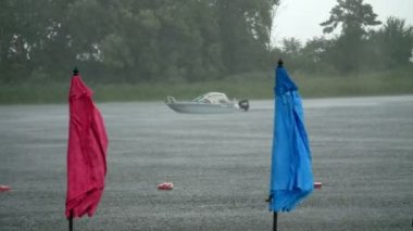 yaz yağmur, fırtına, boş bir plaj, yalnız plaj şemsiye bekliyoruz, ağır yağış güçlü, fırtınalı rüzgar, nehrin üzerinde yavaş yavaş tekne yüzer, bir duş içine düştü.