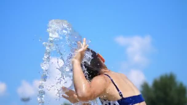 Leende, lycklig åtta-årig flicka i baddräkt som har kul i stänk i gatan staden fontän, Utomhus, i parken, sommar, varm solig dag under semester. — Stockvideo