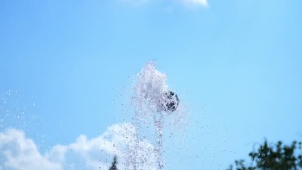 Fontän, stänk, sipprar vatten mot den blå himlen. Vatten av torr fontän närbild. Droppar vatten glittra i solen. sommaren, solig dag. Vatten skytte ur en fontän. — Stockvideo