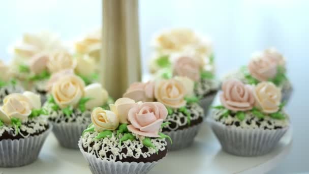 Close-up, uma variedade de deliciosas sobremesas, cupcakes, bolos de creme, chantilly, flores feitas com creme. decoração festiva, bar doce, obras-primas de confeitaria, guloseimas — Vídeo de Stock