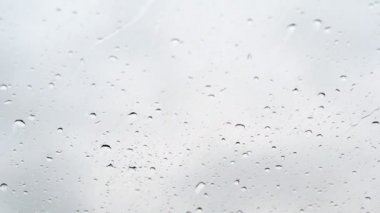 yakın çekim, aracın sürüş sırasında ön cam su damlaları. Aşağı değil, ama yukarı damlacıkları gelen güçlü bir rüzgar, cam akış.