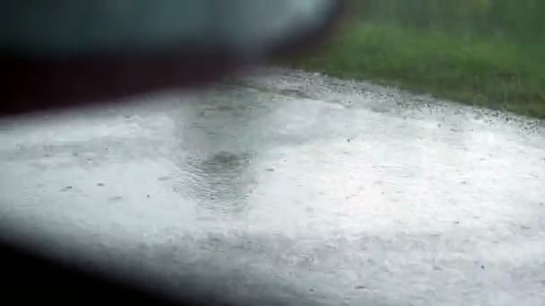 Blick aus dem Autofenster. Nahaufnahme, Fahrbahnrand, Straßenrand, im Regen, während sich das Auto bewegt. Blick aus dem Auto auf nasser Straße — Stockvideo