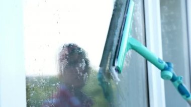 yakın çekim, pencere cam yansıyan gülümseyen beyaz güzel kadın, eldiven, Temizleme, köpük camına bir sürü özel paspas tarafından pencere yıkama. Temizleme Servisi