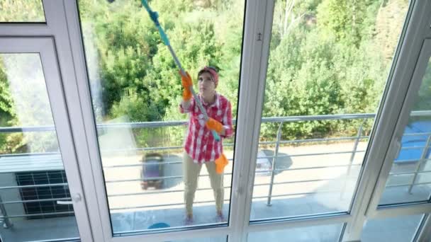 Souriant Caucasien Belle femme, femme au foyer ou travailleuse gaie du service de nettoyage, dans les gants, Nettoyage, laver les fenêtres par une serpillière spéciale, profiter de son travail. Femme de nettoyage — Video