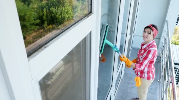 Sonriente caucásica Hermosa mujer, ama de casa o alegre trabajadora de servicio de limpieza, en guantes, limpieza, lavado de ventanas por trapeador especial, disfrutando de su trabajo. Señora de limpieza — Vídeos de Stock