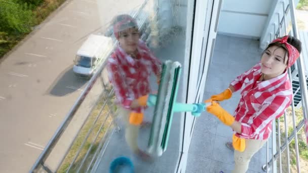 In the window glass is reflected smiling Caucasian Beautiful woman, in gloves, Cleaning, washing Window by special mop, enjoying her work. Cleaning service — Stock Video