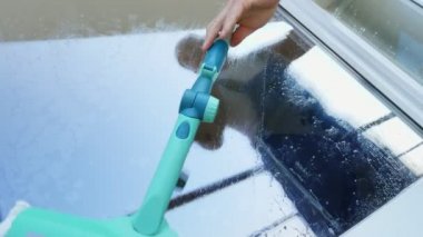 yakın çekim, pencere cam yansıtılır bir adam, Servisi, mavi tulum ve bir kap blaser, temizlik işçisi Temizleme, pencere yıkama tarafından özel paspas,