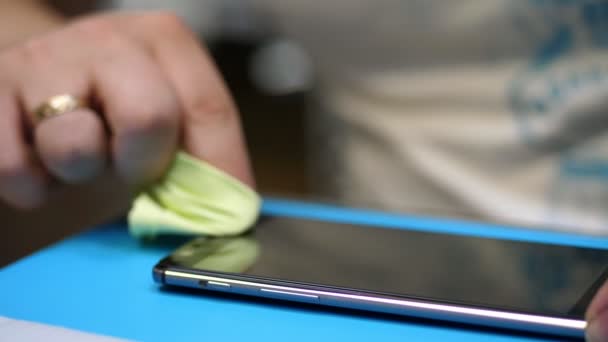 Manos masculinas sosteniendo y limpiando una pantalla de teléfono móvil para poner, aplique un vidrio templado protector para proteger un teléfono inteligente, soporte de mantenimiento y servicio de reparación — Vídeo de stock