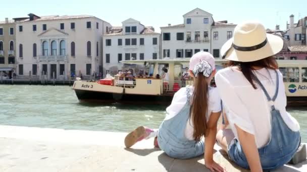 VENICE, ITALY - JULY 7, 2018: tourists, woman in hat and a girl, admiring views of Venice, grand canal. vapareto floats on water, small boats, gondolas sail, on hot summer day, — Stock Video