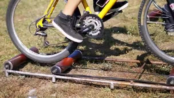 Close-up, de wielen van een oude hometrainer, de fiets rijdt op één plaats met behulp van een speciale zelf-gemaakte meubilair, installatie. — Stockvideo